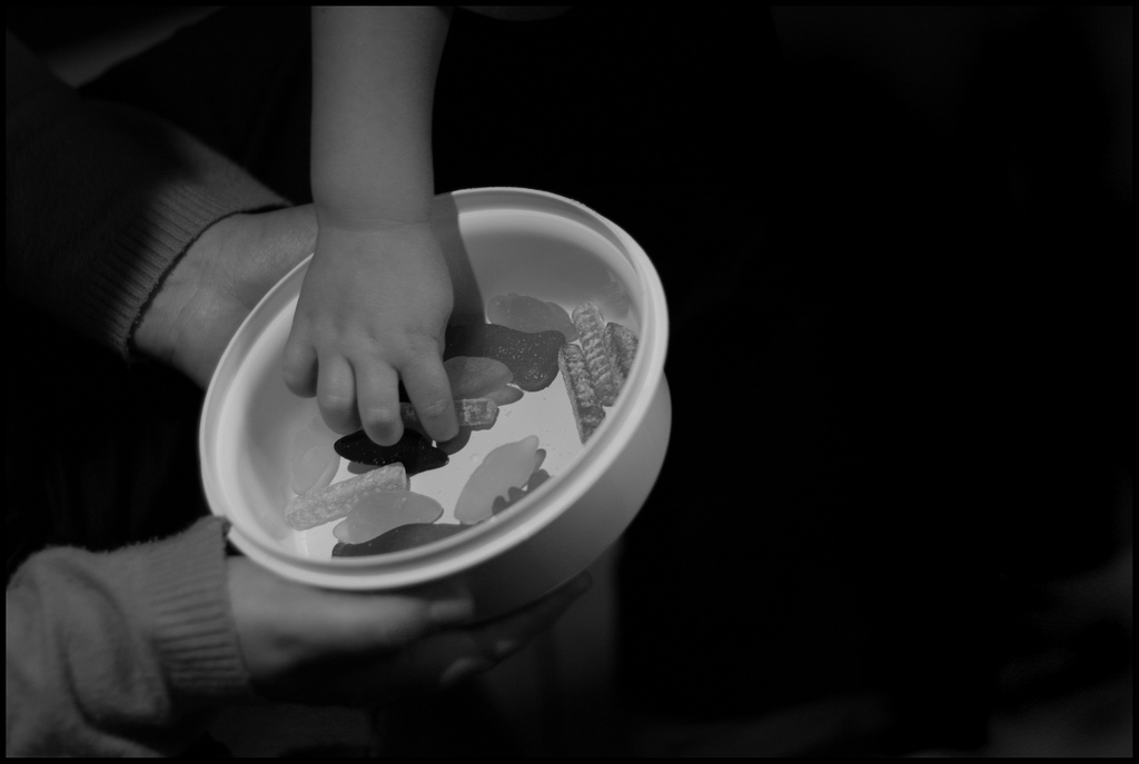 Children share their snack from a tupperware container.