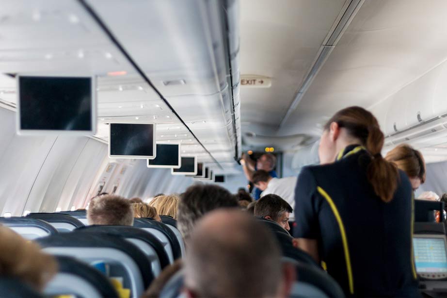 inside an airplane crew serving food and drinks to passengers