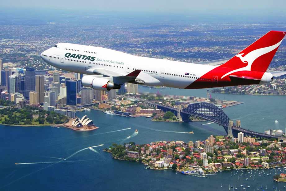Qantas airplane in sky above city
