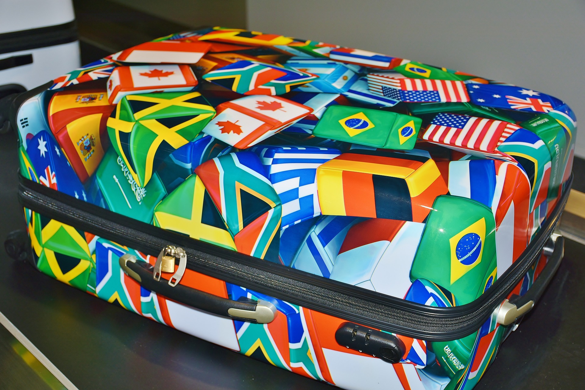 suitcase with flags on it on baggage belt