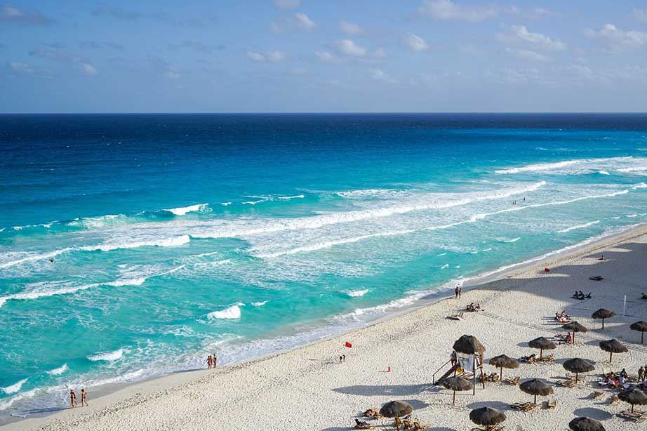 beach in cancun mexico with ocean and blue sky