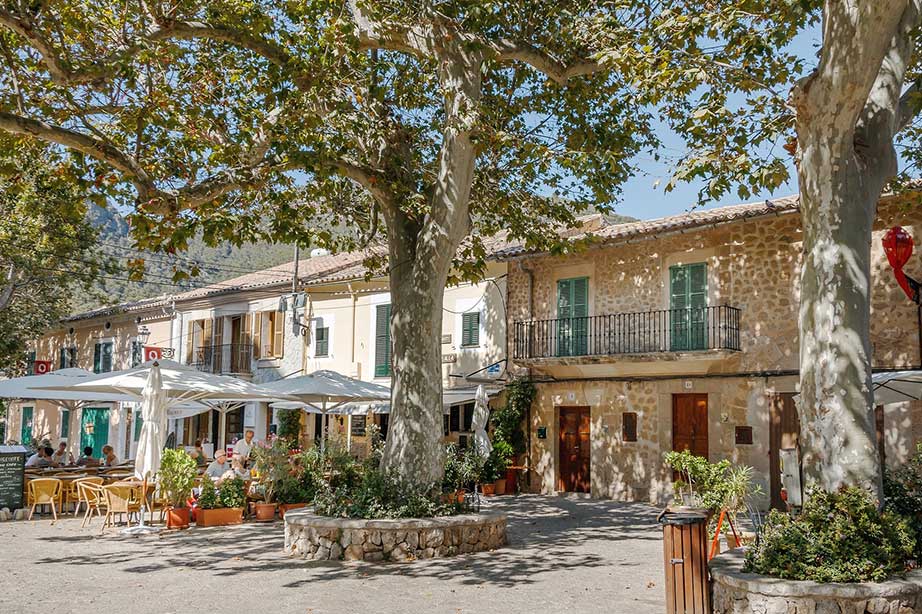 spanish traditional houses with trees and terrace on square