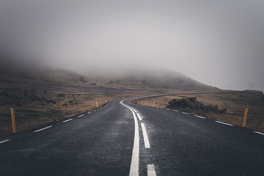road with mountains and fog