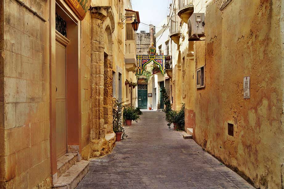 ancient buildings in narrow street of malta