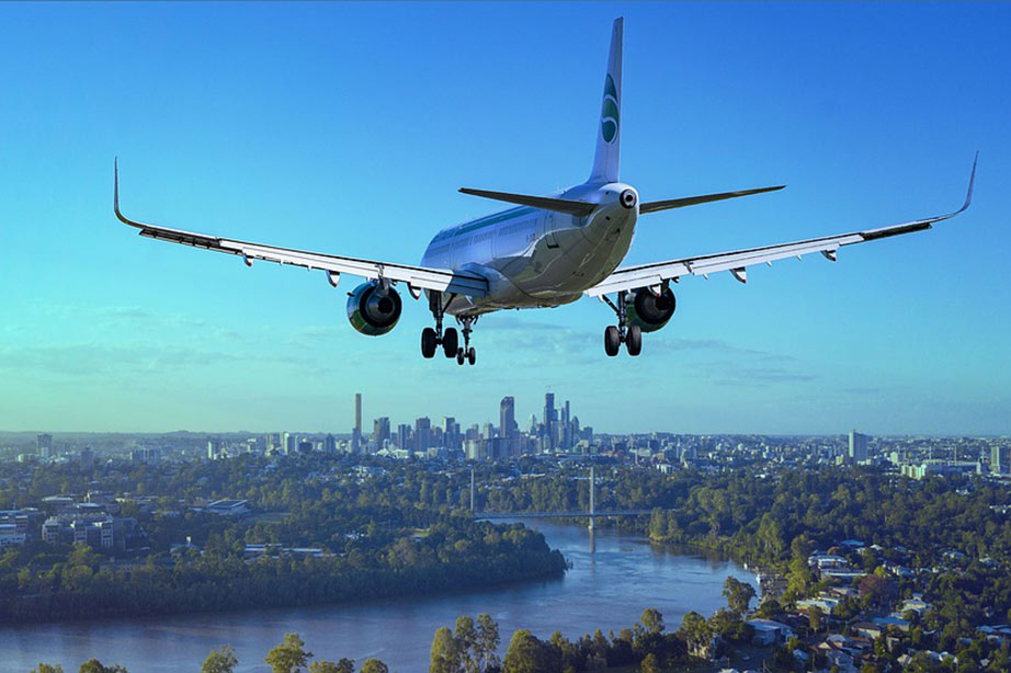 Aircraft approaching city during daytime under a clear blue sky