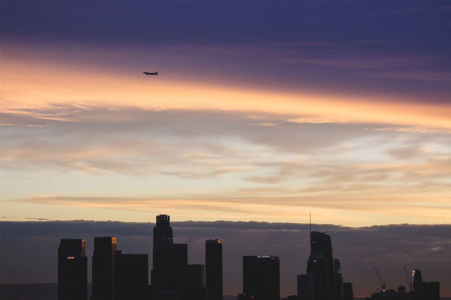 airplane above skyline of city