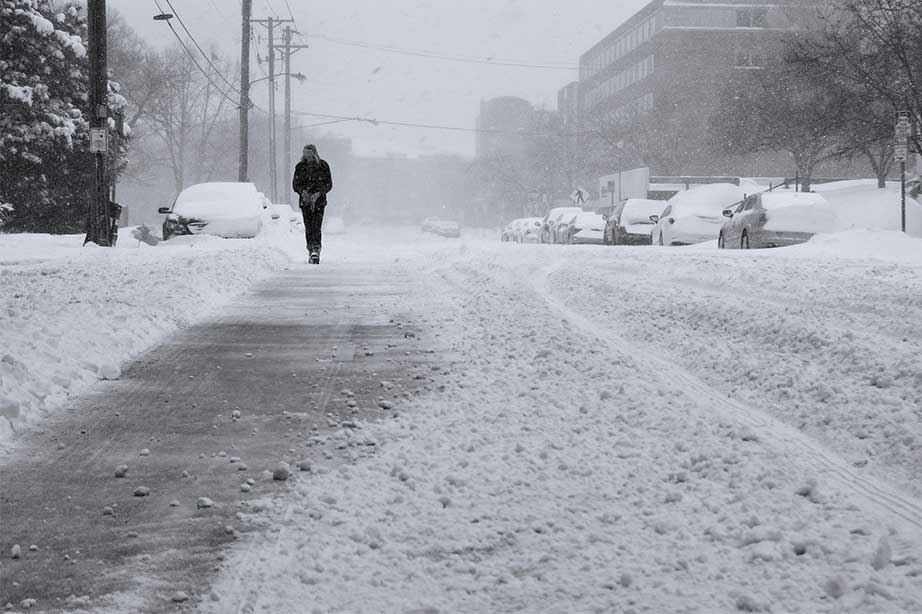 man walks at snow covered street