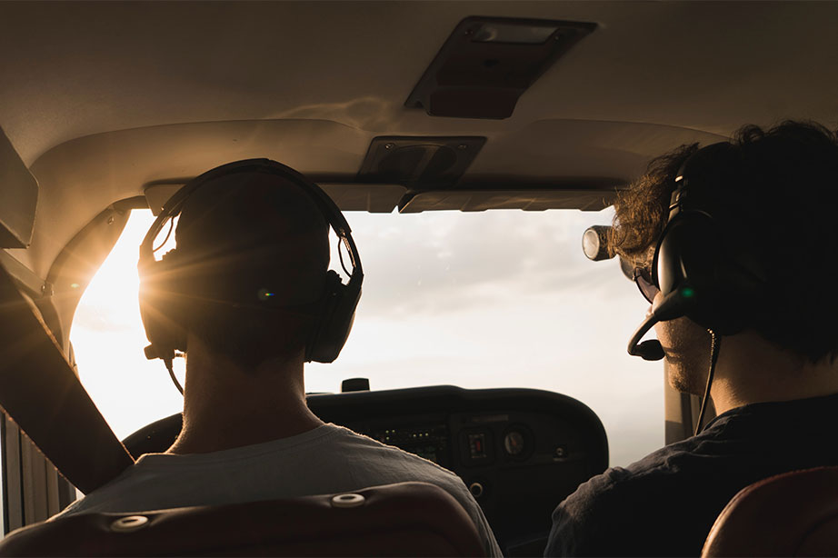 pilots in cockpit with sunset