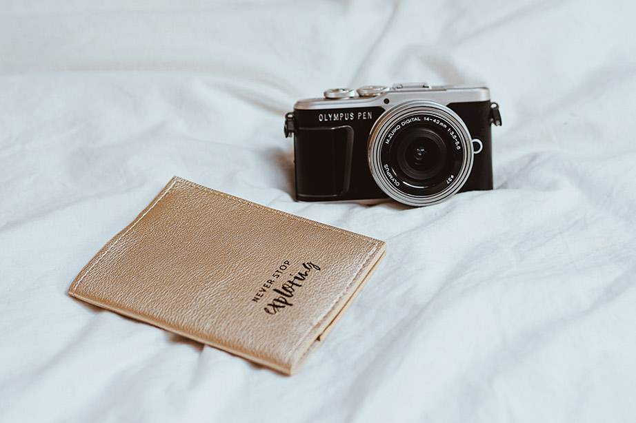 Passport and camera on bed