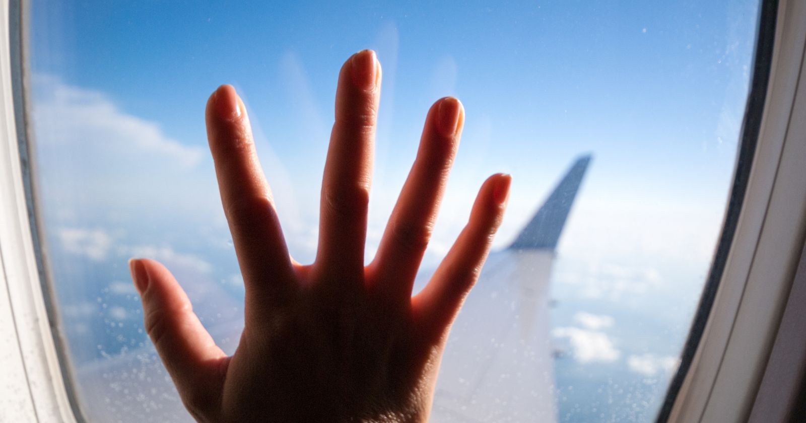 hand on window airplane first-time-flying-tips-tricks-guide