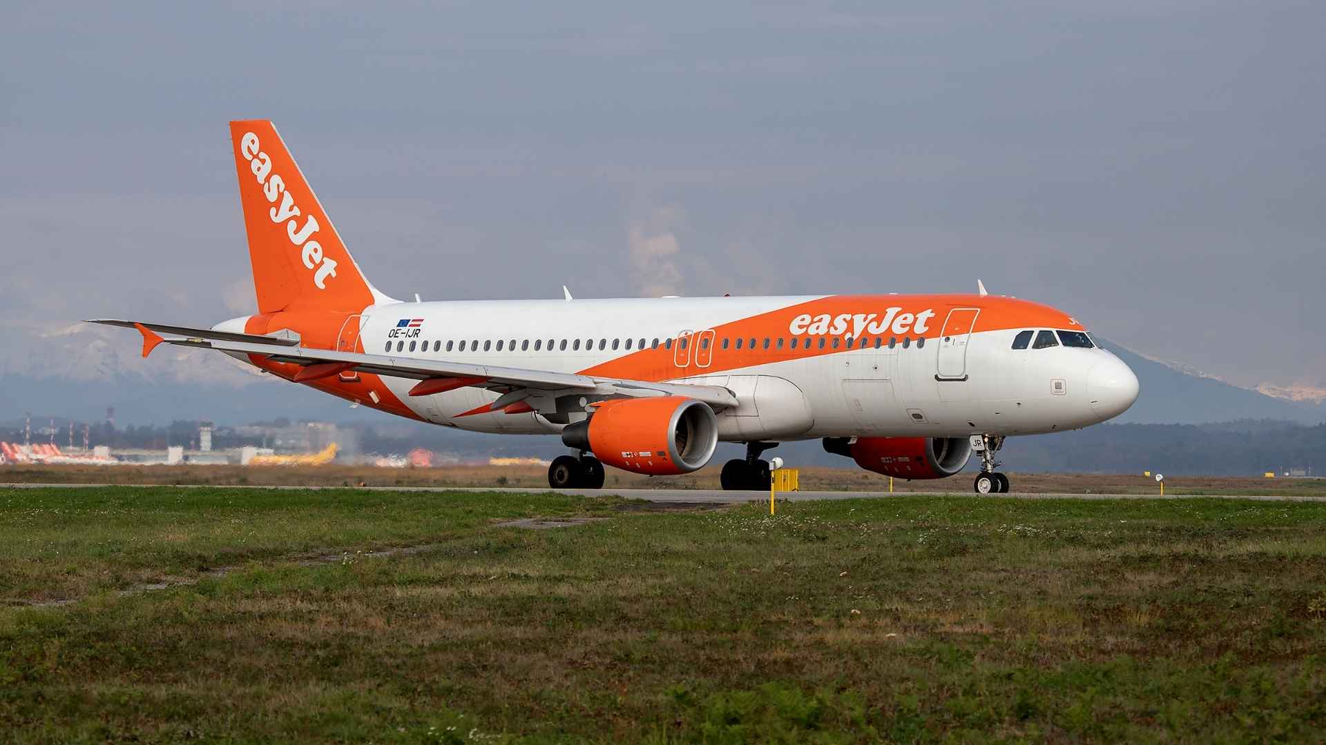 EasyJet-passagiersvliegtuig taxiend over de landingsbaan, met grijze lucht op de achtergrond.